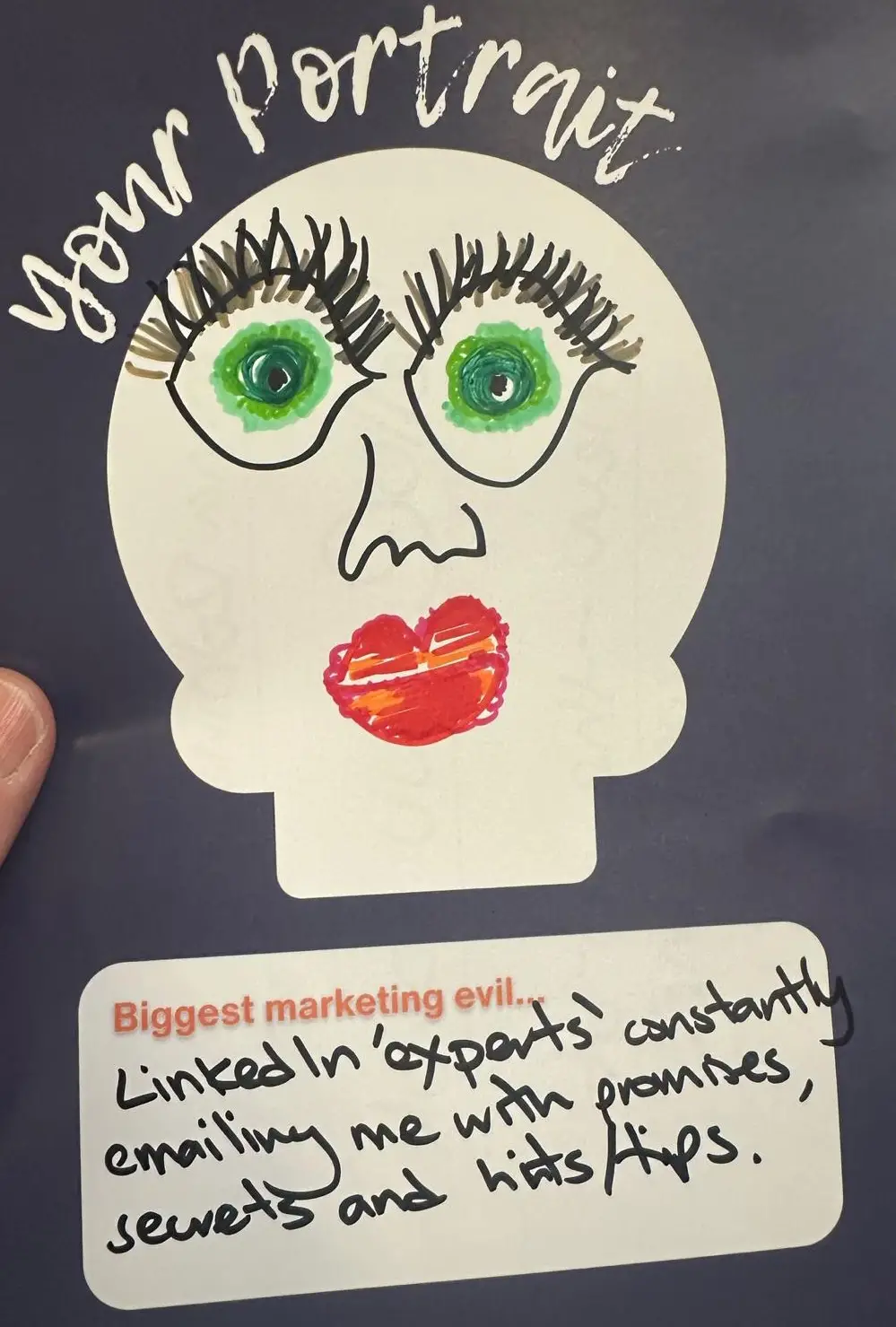 A hand-drawn cartoon marketing strategy exercise portrait on a white head-shaped outline. The face has large green eyes with long exaggerated eyelashes, a small nose, and big red lips. At the top, handwritten text says "your portrait." At the bottom, a printed prompt reads "Biggest marketing evil..." with a handwritten response: "LinkedIn 'experts' constantly emailing me with promises, secrets and hints/tips.